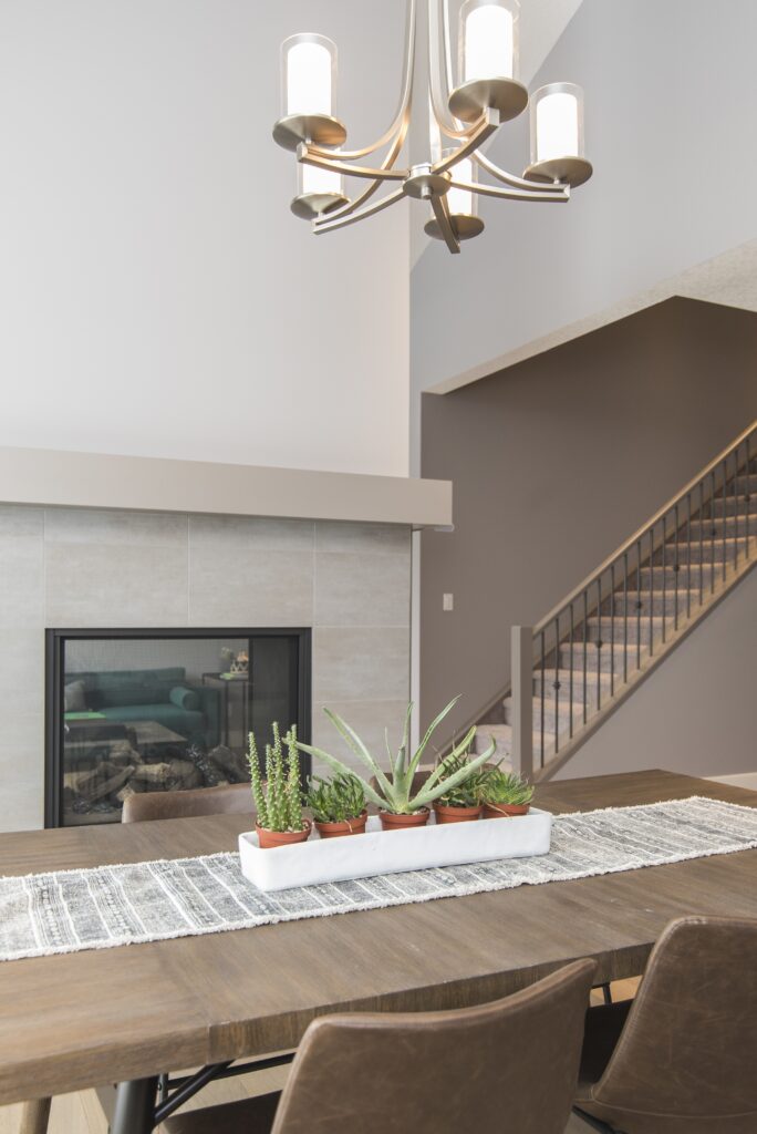 A beautiful shot of a modern house dining room with plants and a fireplace